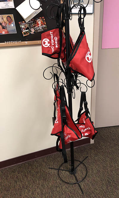 Pet therapy harnesses hang in the Volunteer Services office at Moffitt.