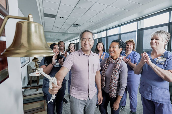 A patient rings a bell to celebrate finishing cancer treatments