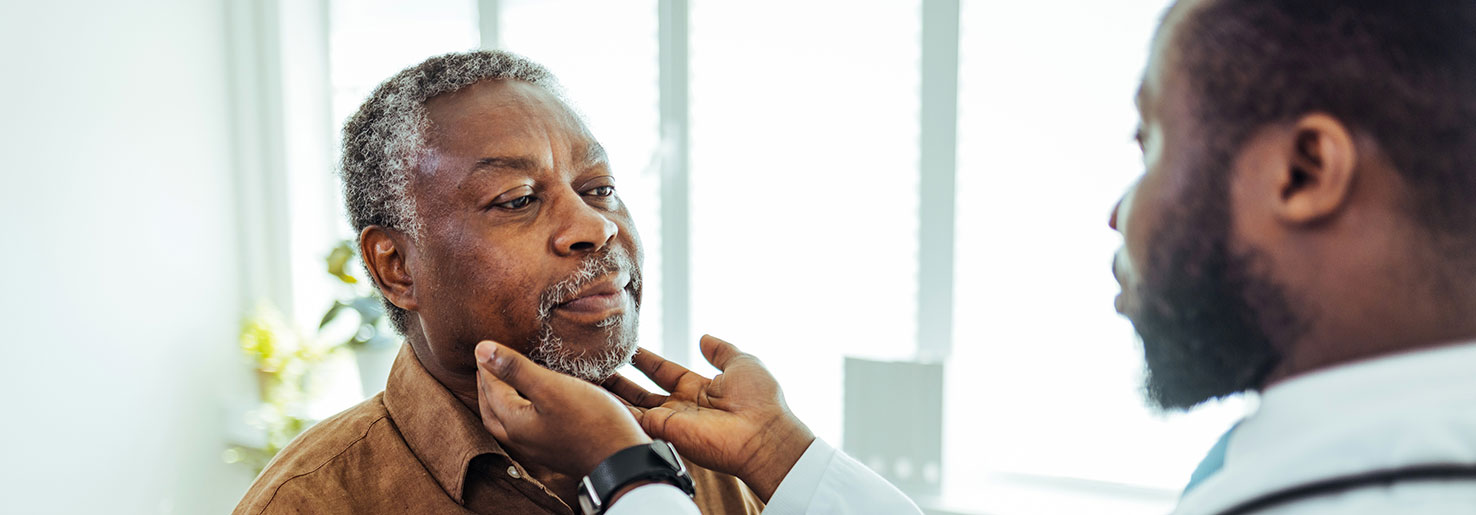 A doctor examining a patient for signs of laryngeal cancer.