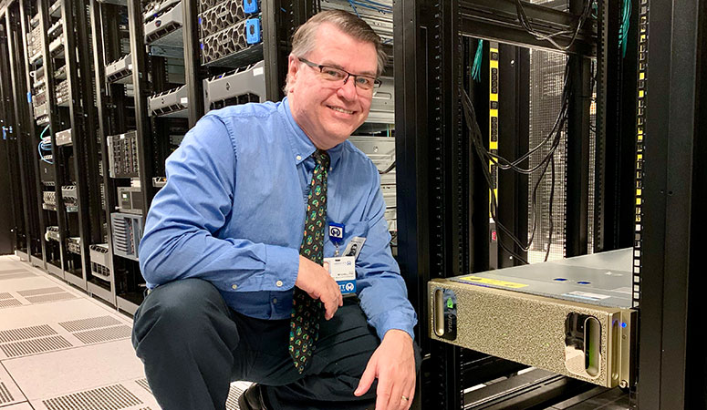 J. Ross Mitchell, PhD, poses in front of Moffitt's supercomputer.