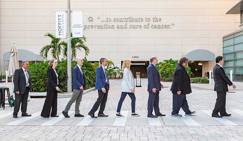 The ReMissions pose in Moffitt's gold valet in the style of the Beatles on Abbey Road.