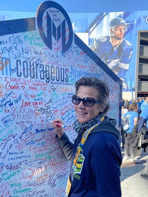 Lisa signs the courage wall at the 2022 Miles for Moffitt.