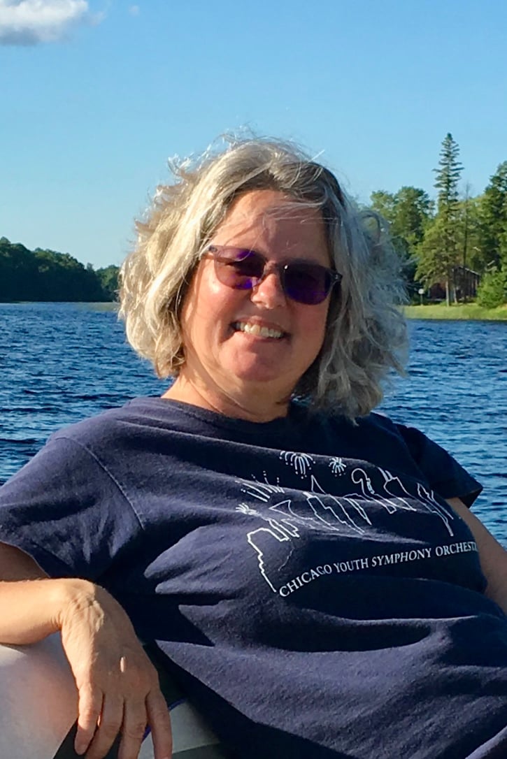Photo of Lynn sitting at a lake