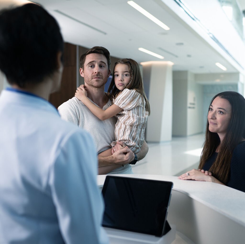 young family checking at Moffitt desk