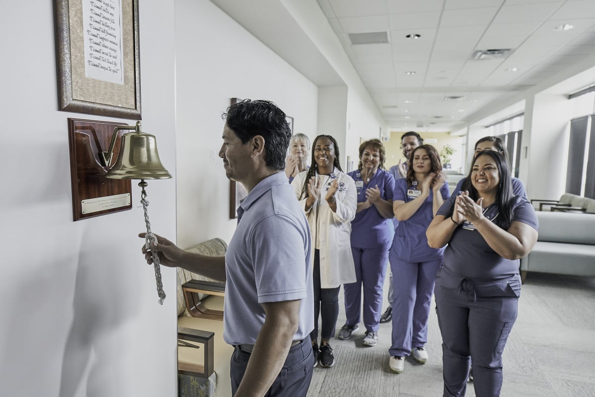 Patient ringing the bell after completing cancer treatment.