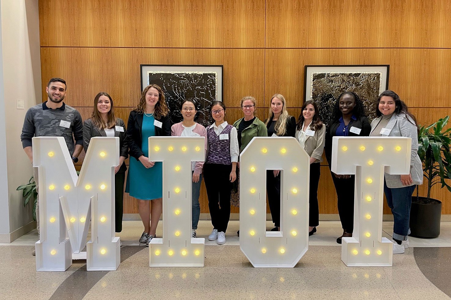 MIOT attendees stand in front of signage