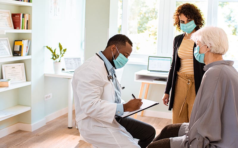 A doctor talks to a patient and her daughter