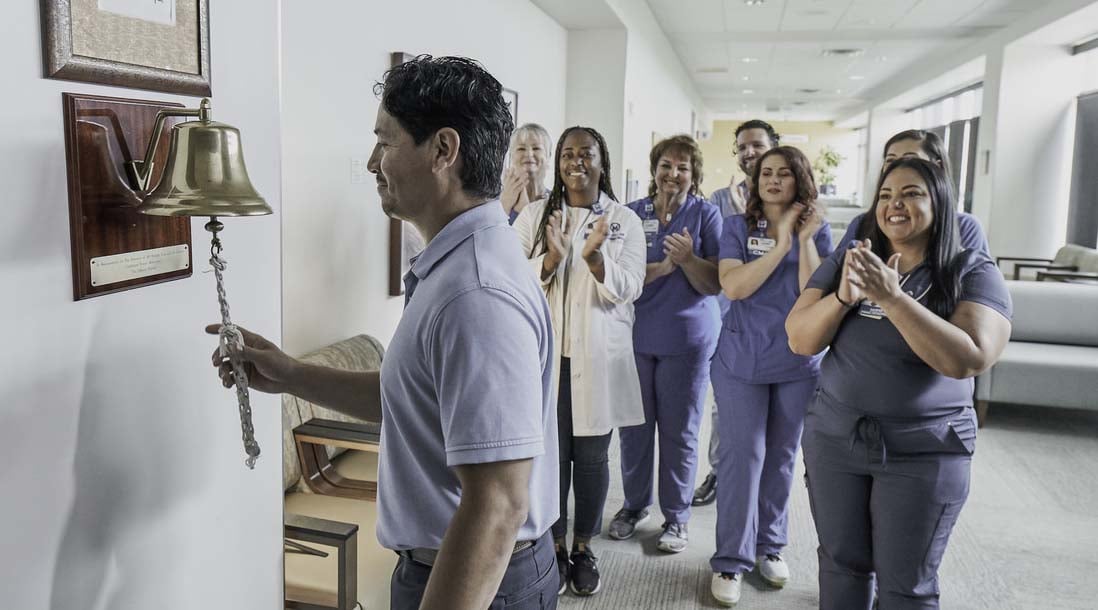 Cancer survivor ringing the bell at Moffitt Cancer Center