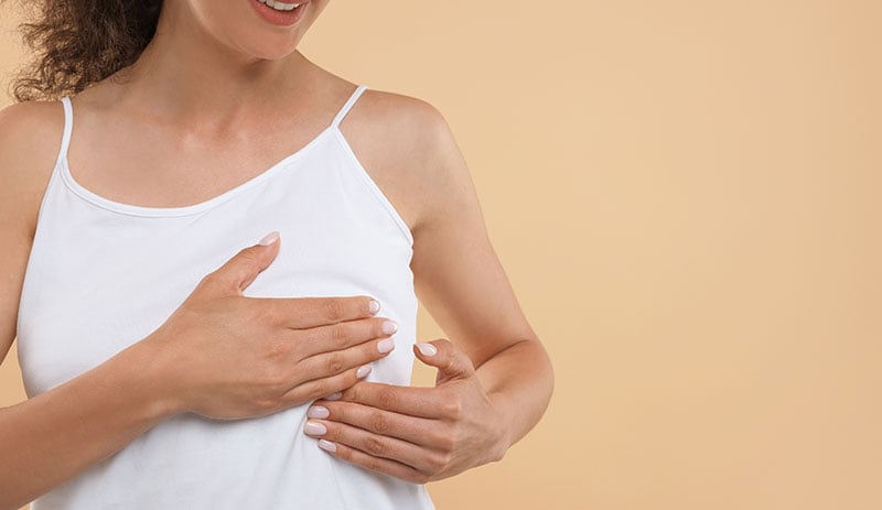 Woman examining breast for lump