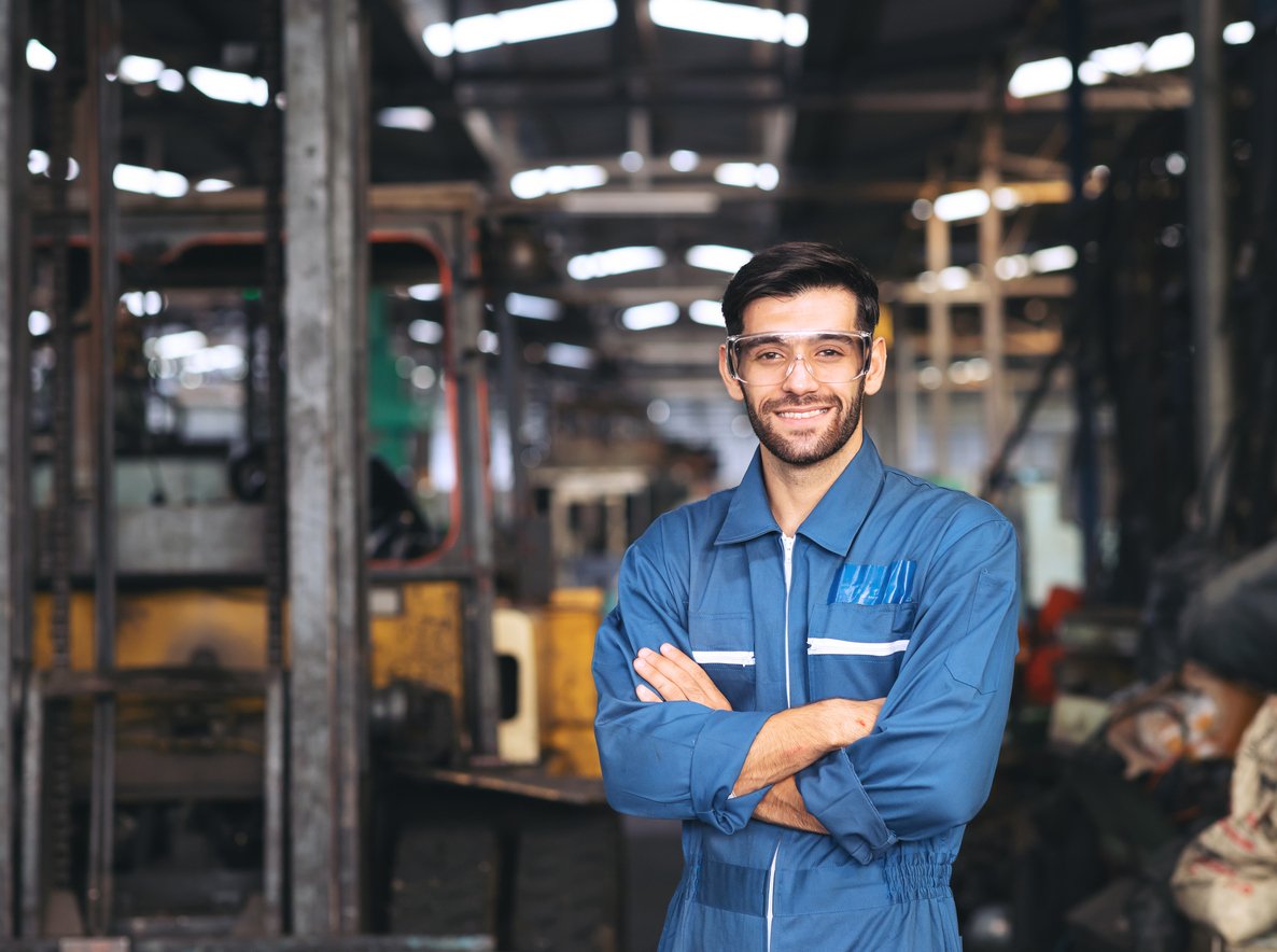 Plant operator man in blue work jumper and protective eyewear 