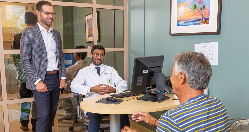Drs. Ben Creelan and Mohammad Alomar meet with a patient