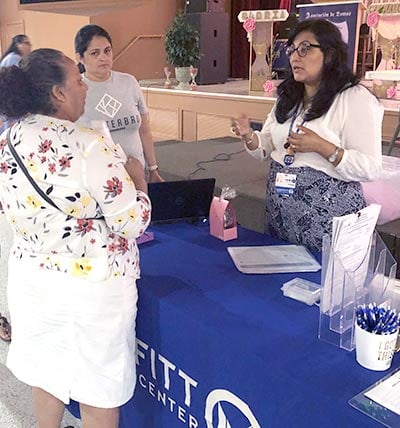 Moffitt staffer talks to a woman at an event