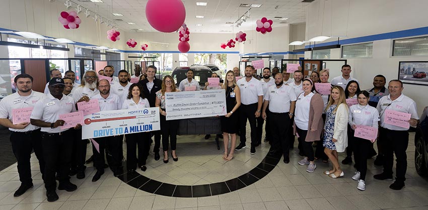 Williams Automotive Group staff presents a check