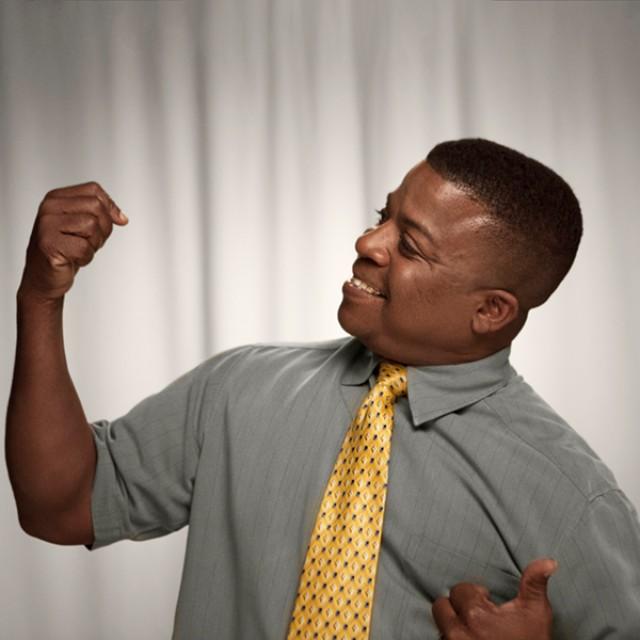 Barney doing a flex pose for the camera after beating prostate cancer