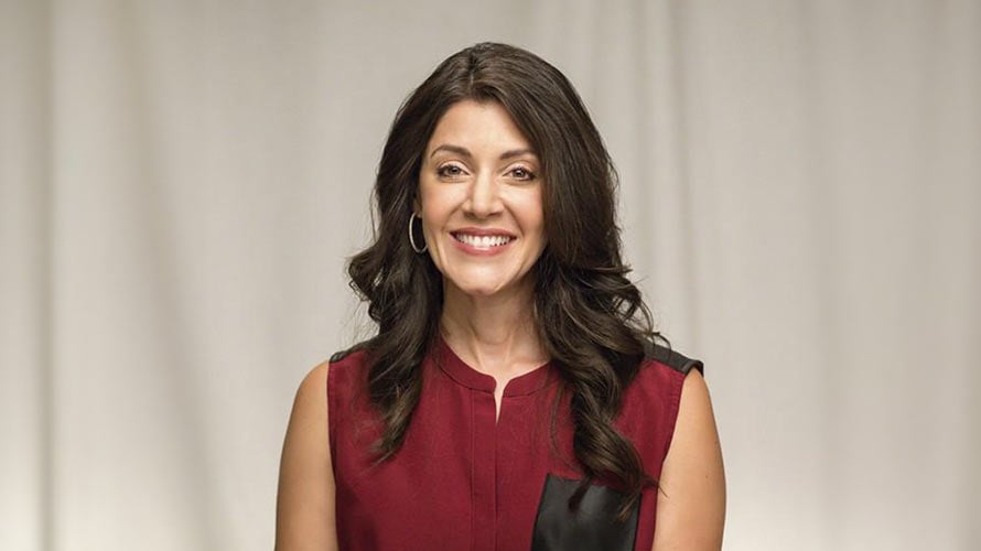 Headshot of Jeanine, thyroid cancer survivor, smiling and wearing a red blouse.