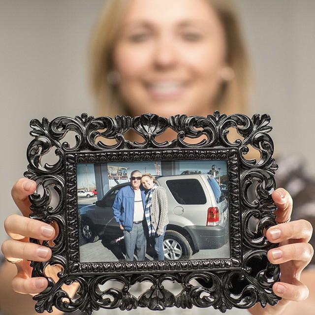 Madison, non-hodgkin lymphoma survivor, holding an image of her grandfather and herself.
