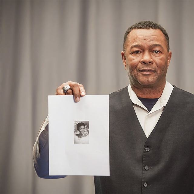 Woodrow, Moffitt volunteer, holding an image of a woman.