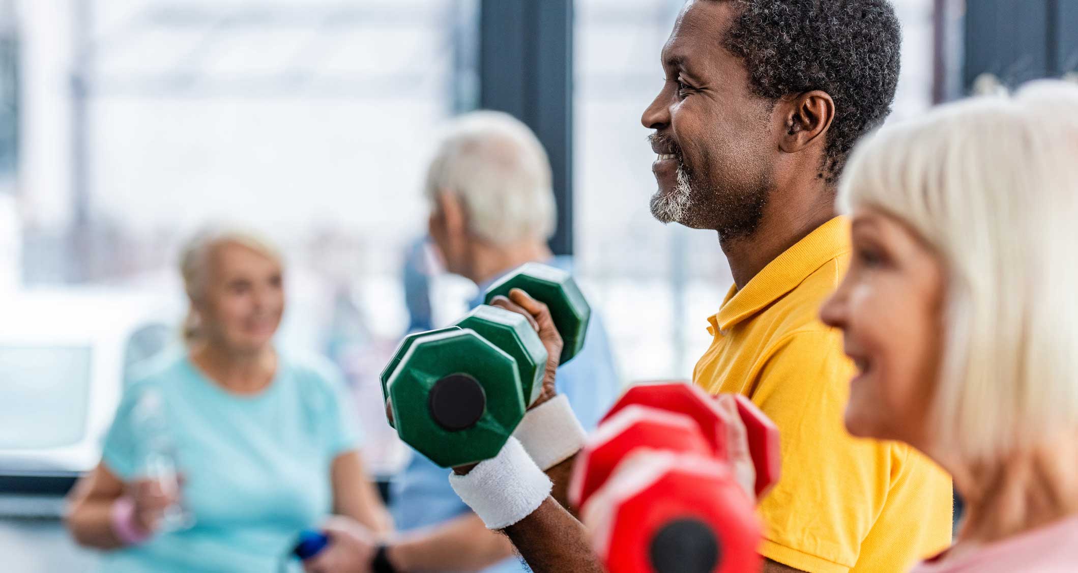 Men and women lifting weights in a gym setting